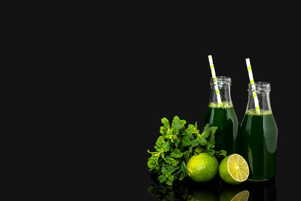 Background photography of green vegetable juice, vegetable fresh, lime, mint, bottle with straw on a black background, blank, copy space, add text. - Foto, immagini