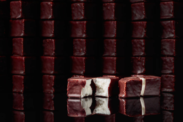 Шоколадные конфеты с молочным суфле на черном отражающем фоне. - Фото, изображение