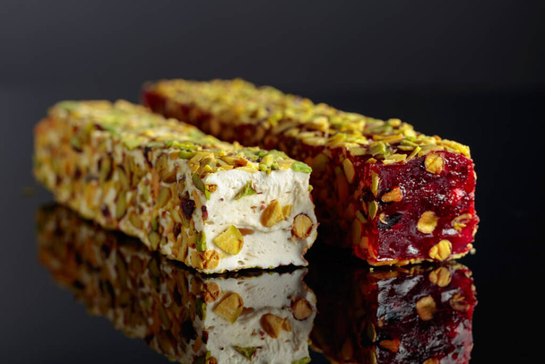 Traditional Turkish delight on a black reflective background. - Photo, Image