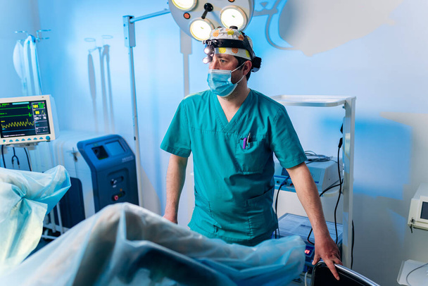 Profesyonel erkek cerrah proktolojist hastanedeki ameliyathanede özel tıbbi aletler kullanarak ameliyat yapıyor. Acil cerrahi konsept - Fotoğraf, Görsel