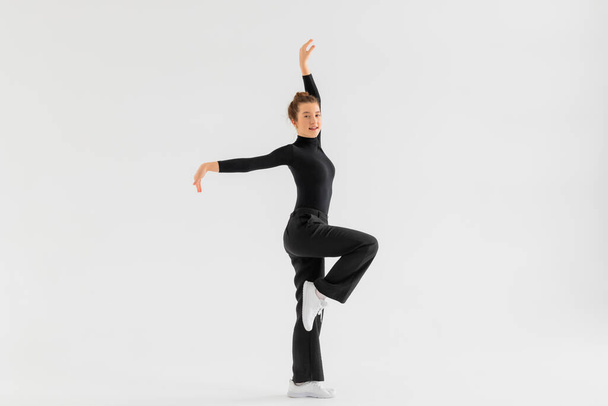 Young Girl, professional hip-hop dancer in a black clothes performing over a Isolated white background with a plenty of copy space. - Photo, Image