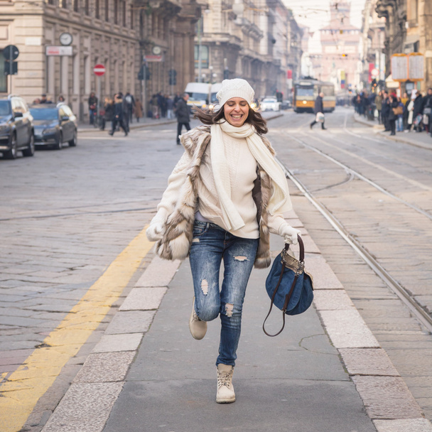 Beautiful young woman running in the city streets - Foto, afbeelding