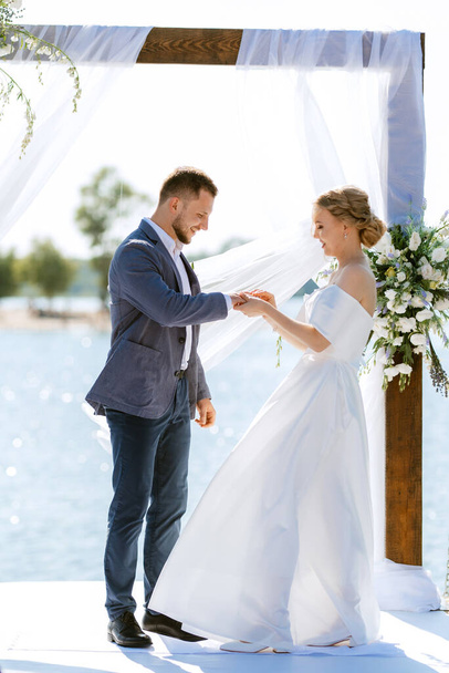 wedding ceremony on a high pier near the river with invited guests - Foto, immagini