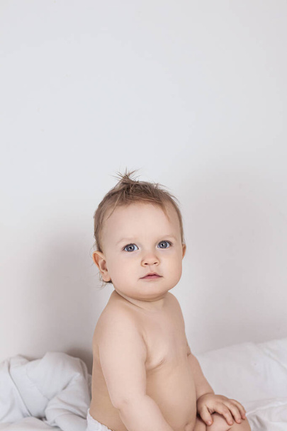 baby on a white blanket in a diaper. High quality photo - Foto, Imagem