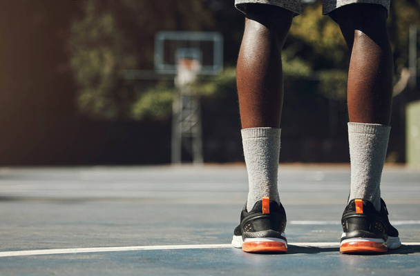 Basketbal, sneakers en atleet zwarte man staan op het sportveld voor wedstrijd, motivatie en streetball geheugen. Mannenspeler buiten in USA met sportschoenen aan de voeten voor fitness en beweging. - Foto, afbeelding