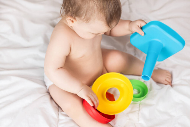Cute baby playing with colorful rainbow toy pyramid. Toys for little kids.  - Foto, immagini