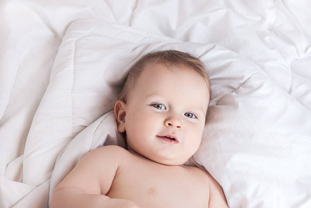 Baby auf einer weißen Decke in einer Windel. Hochwertiges Foto - Foto, Bild