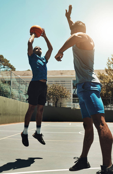 Basketball, sports game and man shooting for goal, fitness exercise and training workout on outdoor basketball court. Street competition, winner mindset and healthy athlete jump and playing match. - Fotó, kép