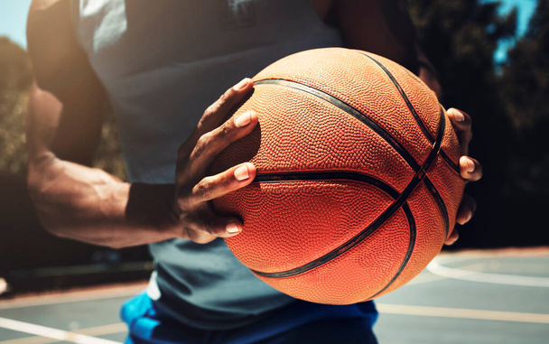 Basketball, basketball player and athlete hands closeup holding ball on basketball court in urban city park outside. African man, sports fitness and healthy lifestyle wellness training outdoors. - Photo, image