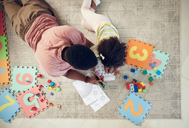 Home, toys and child with father support and helping with homework and coloring for school. Living room carpet, parent care and kid from above with dad and daughter with knowledge development. - Foto, Bild