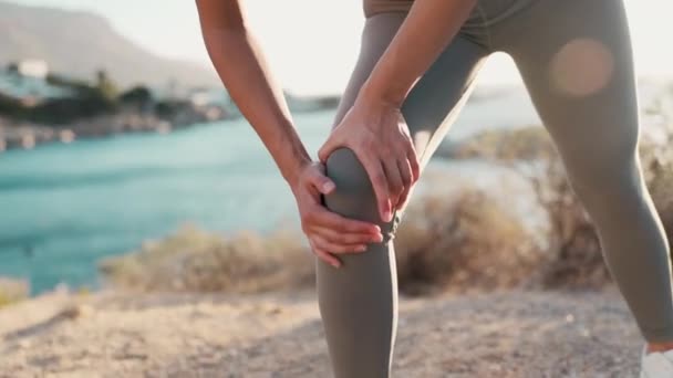 Knie pijn, oefening letsel en handen van wandelende vrouw houden been met medische probleem van fitness. Outdoor, sportongeluk en hardlopen vrouwtje op een natuurpark pad gevoel benen spierspanning. - Video