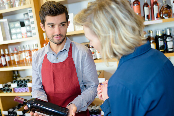 wine seller making recommendation to customer - Foto, Bild