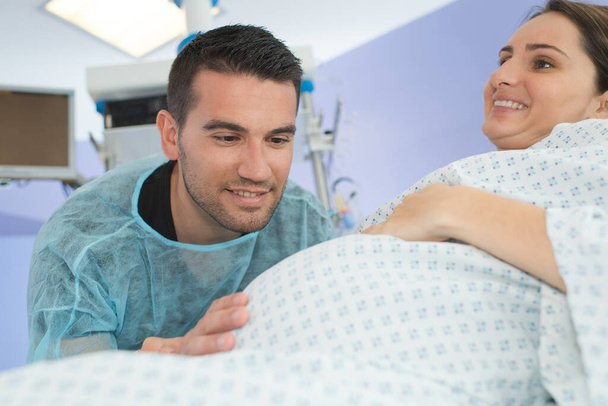 husband looking lovingly at wifes bump during childbirth - Foto, imagen