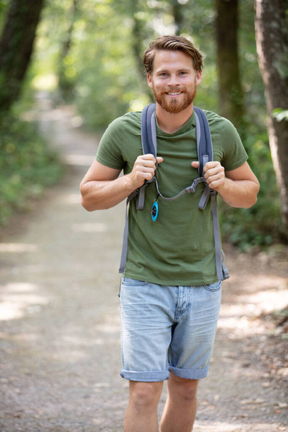 male hiker looking to the side walking in forest - Foto, Imagem