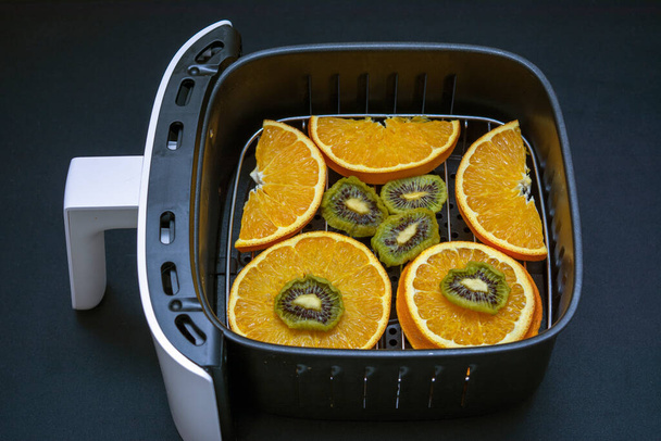 Freidora de aire con frutas listas para deshidratar y secar en ella. - Foto, Imagen