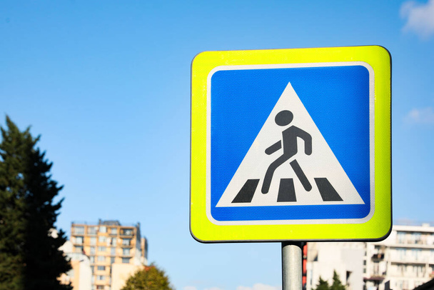 Road sign Pedestrian Crossing against blue sky on city street - Photo, Image