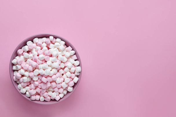 Bowl with delicious marshmallows on pink background, top view. Space for text - Foto, Imagem
