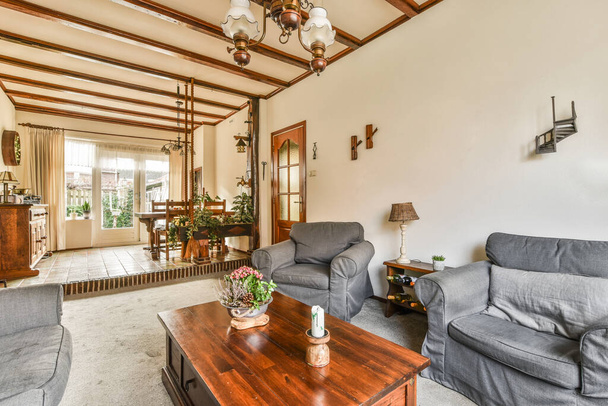 egy nappali két kanapéval és egy dohányzóasztal a szobában fehér falak, fa gerendák és exponált mennyezet - Fotó, kép