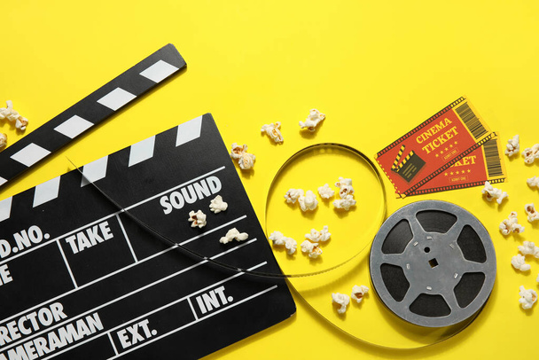 映画クラッパーとともにリール、ポップコーンとチケット上の黄色の背景 - 写真・画像