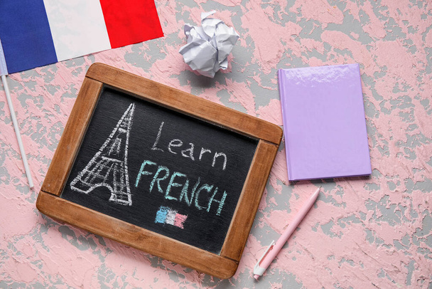 Доска с текстом на французском языке, блокнот, скомканная бумага и флаг Франции на гранж-фоне - Фото, изображение