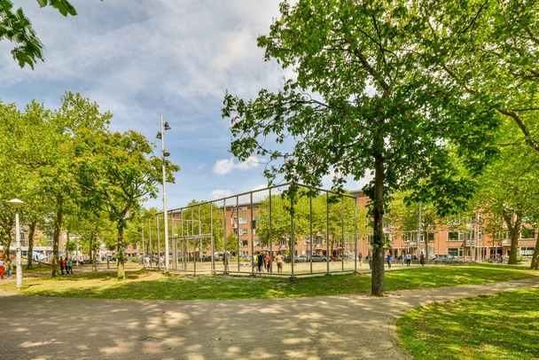 Amsterdam, Netherlands - 10 April, 2021: a park with trees and people in the distance, on a sunny day that has been taken out for many years - 写真・画像
