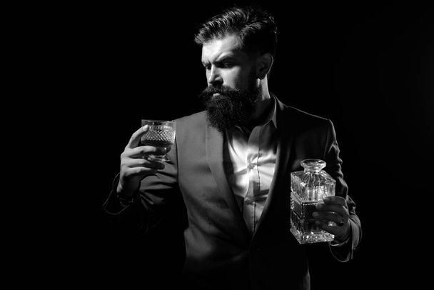 Whisky elegant. Man with beard holds glass of brandy. Bearded businessman in elegant suit with glass of whiskey. Luxury beverage concept - Φωτογραφία, εικόνα
