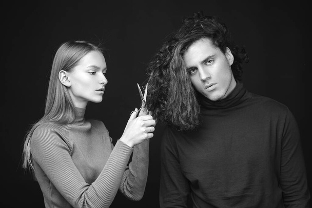 Hair salon concept. Hairdresser girl going to cut off long wavy bleached dry hair of customer man. Man hair style, wellness and fashion. Female with scissors going to do amazing man haircut - Photo, image