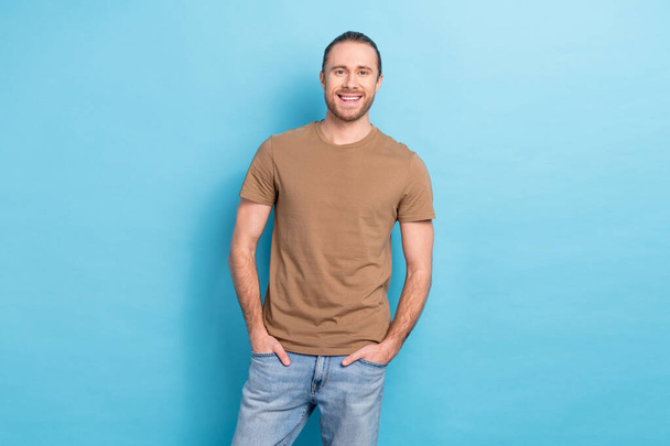 Portrait of satisfied glad young man put hands pockets posing toothy smile isolated on blue color background. - Photo, image