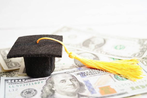 Graduation gap hat on US dollar banknotes money, Education study fee learning teach concept. - 写真・画像