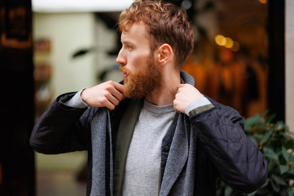 Портрет стильно одягненого бородатого чоловіка, який позує на вулиці
 - Фото, зображення