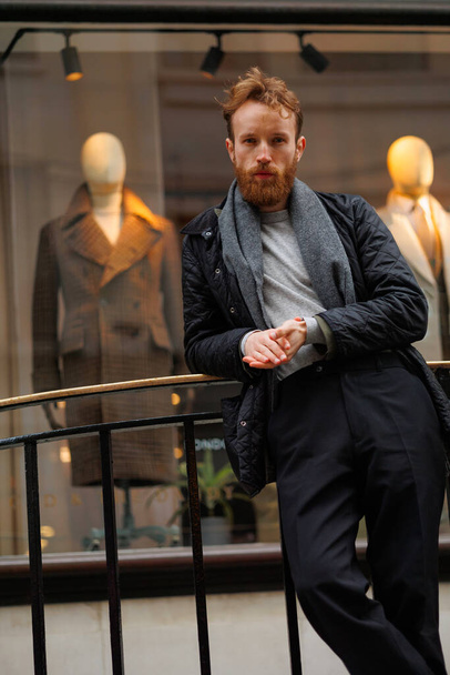 Portrait of a stylish bearded man against the background of elegant clothing store window - Фото, изображение