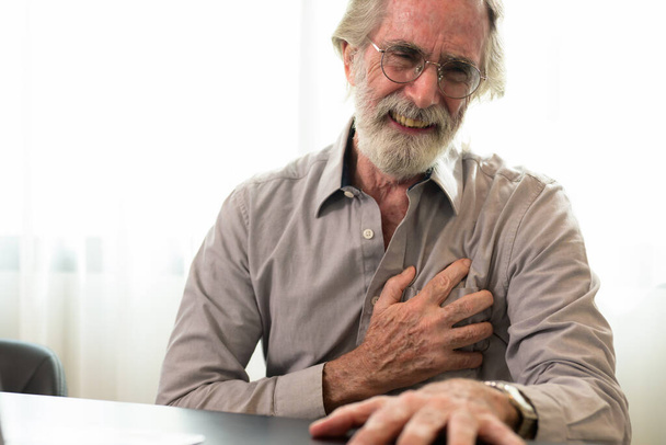 Hombre mayor cogido de la mano en el pecho y que sufre de problemas del corazón en el hogar, Abuelo con ataque al corazón sufren, Personas con problemas de salud - Foto, imagen