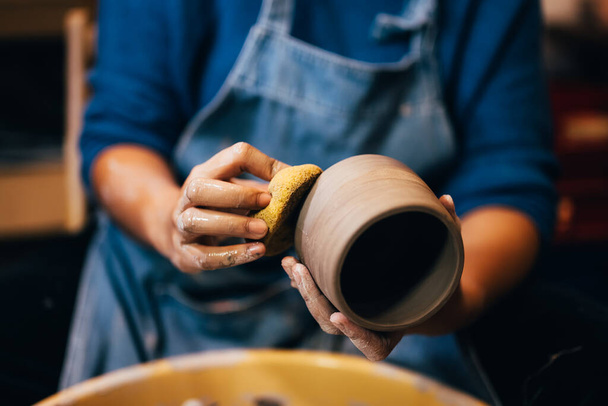 Professional craftsman potter making jug of clay on the potters wheel circle in workshop, Traditional handicraft working, Creativity and art of pottery - Foto, imagen