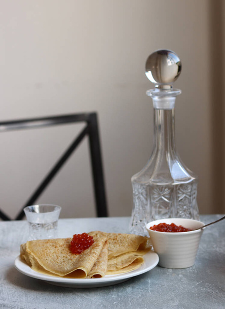 Crêpes, kaviaar en wodka op een tafel. Voedsel stilleven foto. Minimalistische compositie stilleven met zure maaltijd.  - Foto, afbeelding