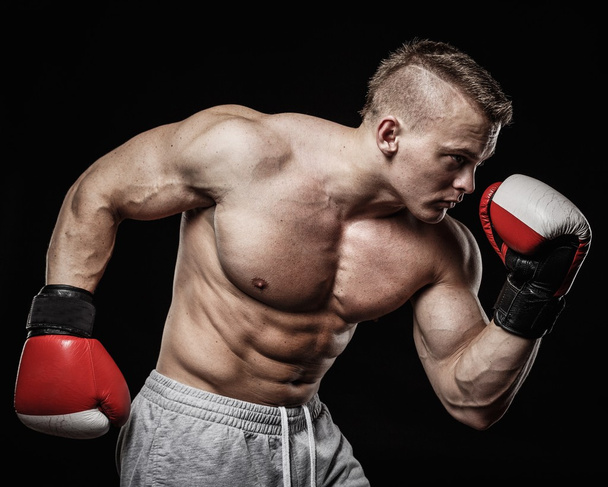 muskulöser Mann mit Boxhandschuhen - Foto, Bild