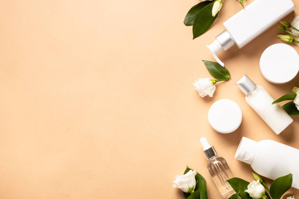 Natural cosmetic products. Cream, serum, tonic with green leaves and flowers. Flat lay image with copy space. - Фото, изображение