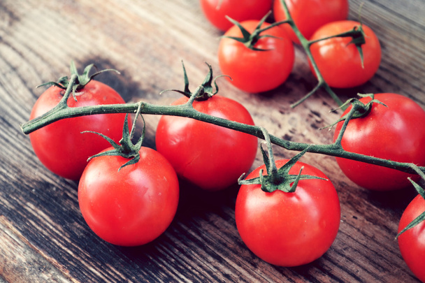 Kilka małych czerwone pomidory na drewnianym stole - Zdjęcie, obraz