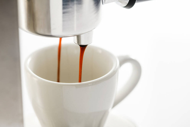 Espressomaschine, die starken frischen Kaffee in eine Keramiktasse gießt, Nahaufnahme. - Foto, Bild