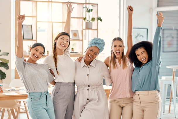 Empowerment, success and portrait of group of women celebrating achievement, win and victory in startup. Teamwork, diversity and businesswomen in celebration with hands in air in creative workspace. - Photo, image