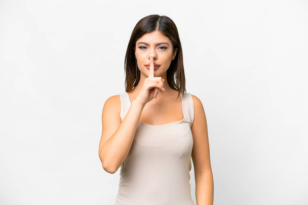 Молода російська жінка через ізольоване біле тло, що показує знак мовчання, який кладе палець у рот. - Фото, зображення