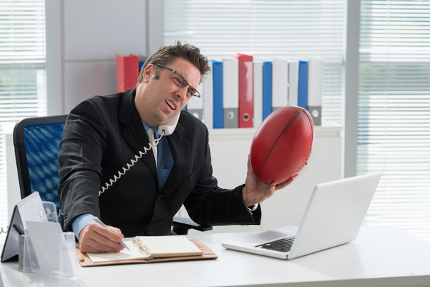 Businessman with a ball talking on the phone - Фото, зображення