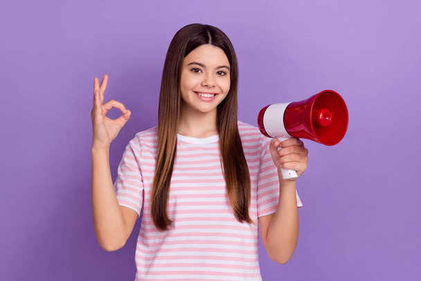Photo of pretty sweet girl dressed striped t-shirt rising toa showing okey gesture isolated purple color background. - Foto, afbeelding