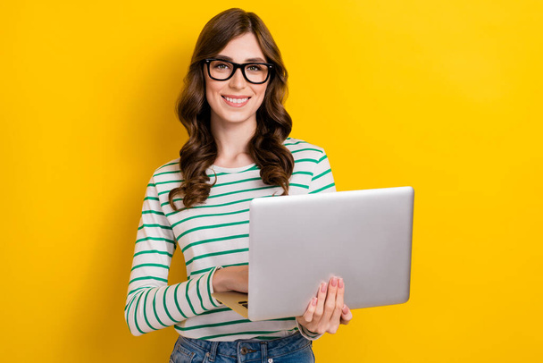 Photo of brown curly hair young professional programmer positive woman hold netbook creative project seo manager isolated on yellow color background. - Fotó, kép