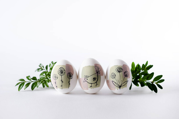  Сучасні творчі модні ручні розмальовані великодні яйця на білому тлі. Саморобна традиція Великодні ідеї
. - Фото, зображення
