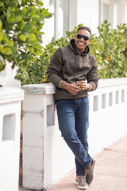 full length of joyful african american man in hoodie and stylish sunglasses standing outdoors  - Φωτογραφία, εικόνα