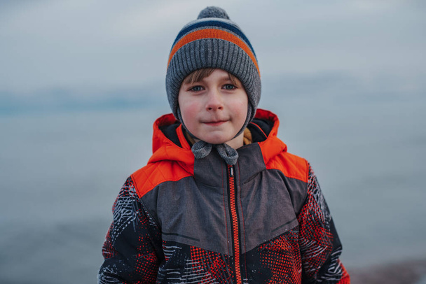 Child winter portrait on lake background - Zdjęcie, obraz