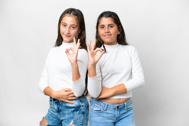 Friends girls over isolated white background showing an ok sign with fingers - Foto, immagini