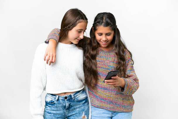 Amigos chicas sobre fondo blanco aislado enviando un mensaje o correo electrónico con el móvil - Foto, Imagen