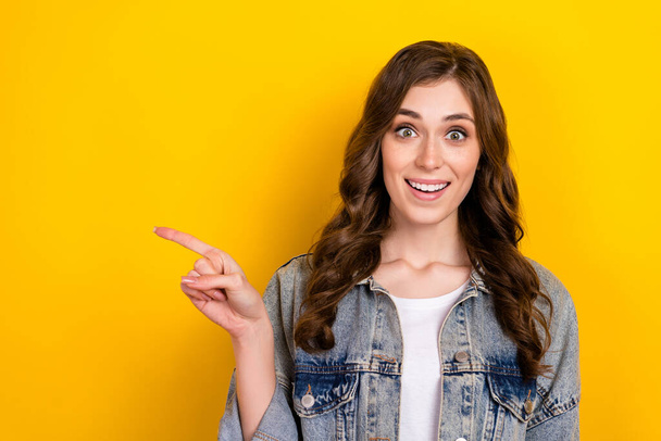Photo of positive pretty lady indicate finger empty space information isolated on yellow color background. - Foto, afbeelding