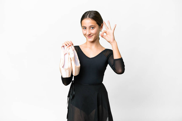 fiatal nő gyakorló balett izolált fehér háttér mutatja rendben jel ujjakkal - Fotó, kép